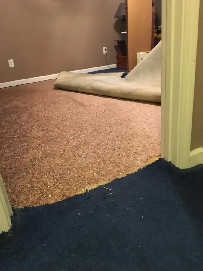 Carpet pad removal revealing water damage during Water Mitigation Services in Grenada